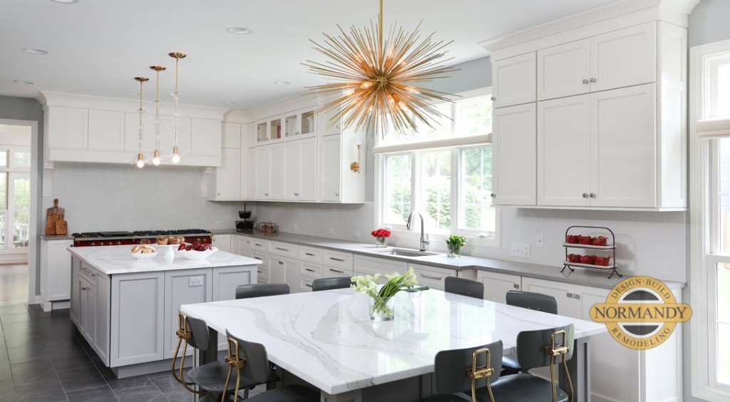 Long, white kitchen takes advantage of the space with two islands, each with their own purpose