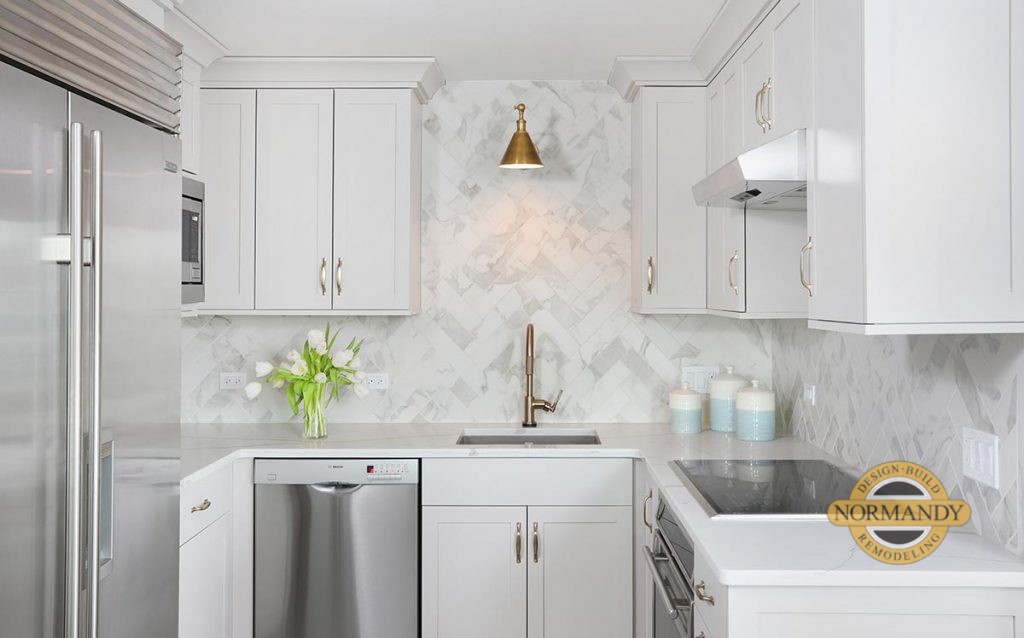 Light Gray cabinets, subzero fridge, stainless appliances, marble-look backsplash