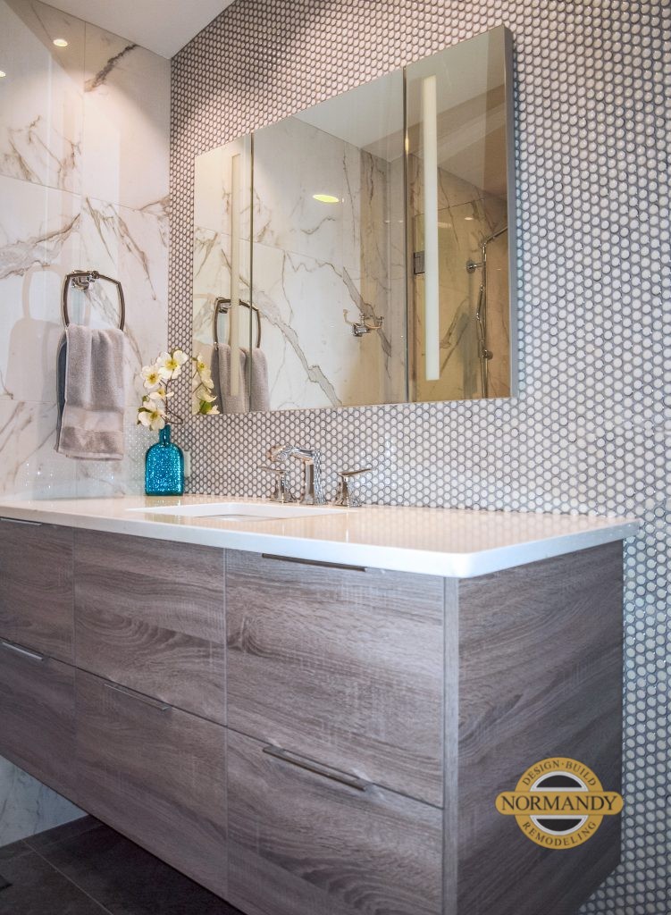 Woodgrain laminate floating vanity with tile accent wall and light up medicine cabinet