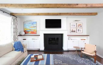 Family room with fireplace and wood beams on teh ceilinjg