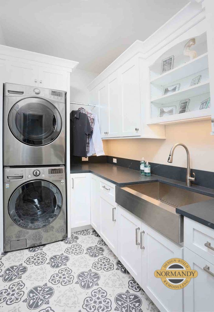 laundry room with stainless steel apron front sink and stacked washer and dryer