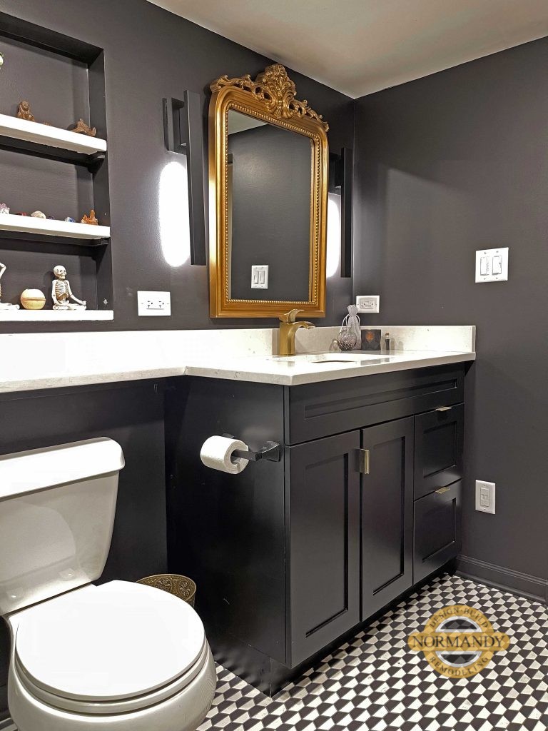 Black bathroom vanity cabinet with gold mirror and gold tone faucet