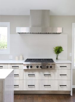 Modern kitchen with cooktop and stainless steel hood