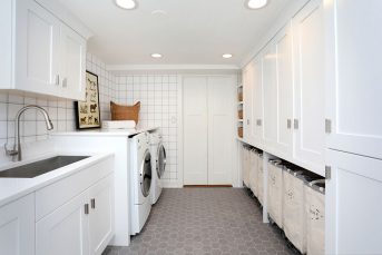 Lower level laundry room, storage cabinets, laundry sorting, sink, upper cabinets