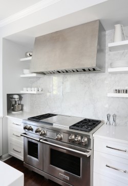 Kitchen with slab backsplash, hammered metal range hood and open shelving