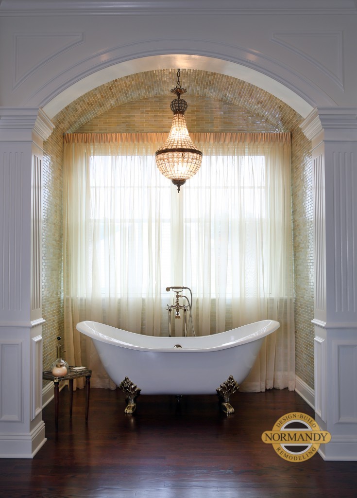 Clawfoot tub with chandelier in tiled barrel ceiling