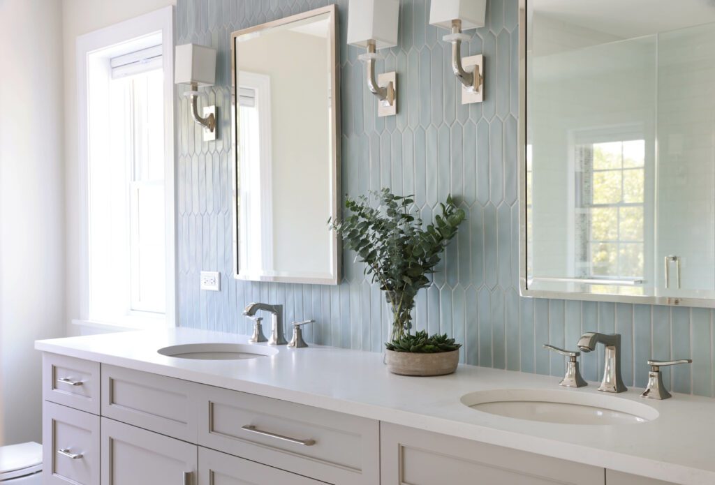 primary bathroom with a double vanity and blue backsplash tile