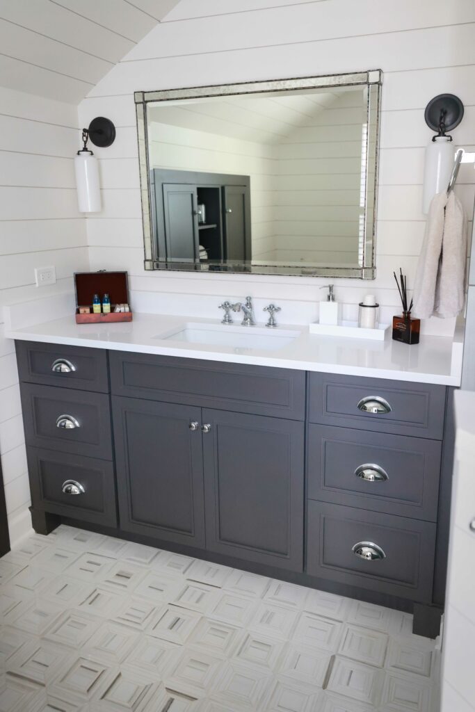 farmhouse style bathroom with dark vanity and white shiplap walls