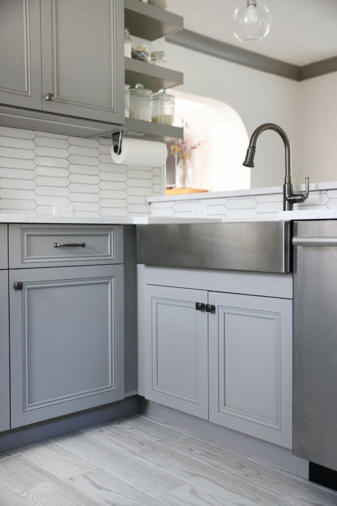 stainless steel apron front sink in gray kitchen