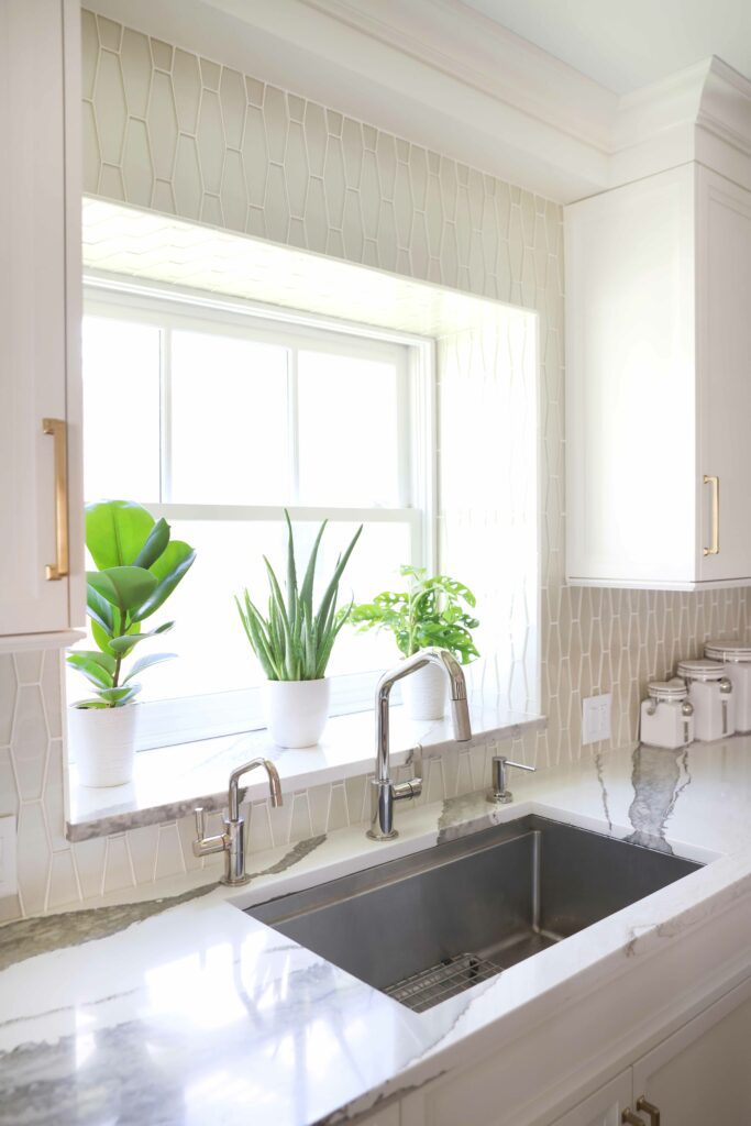 quartz countertop with stainless steel sink and glass tile backsplash