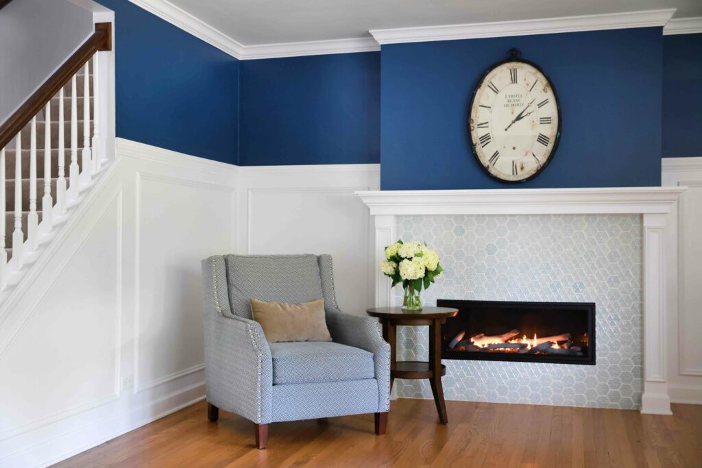 light blue fireplace surround with paneling on the walls in the living room