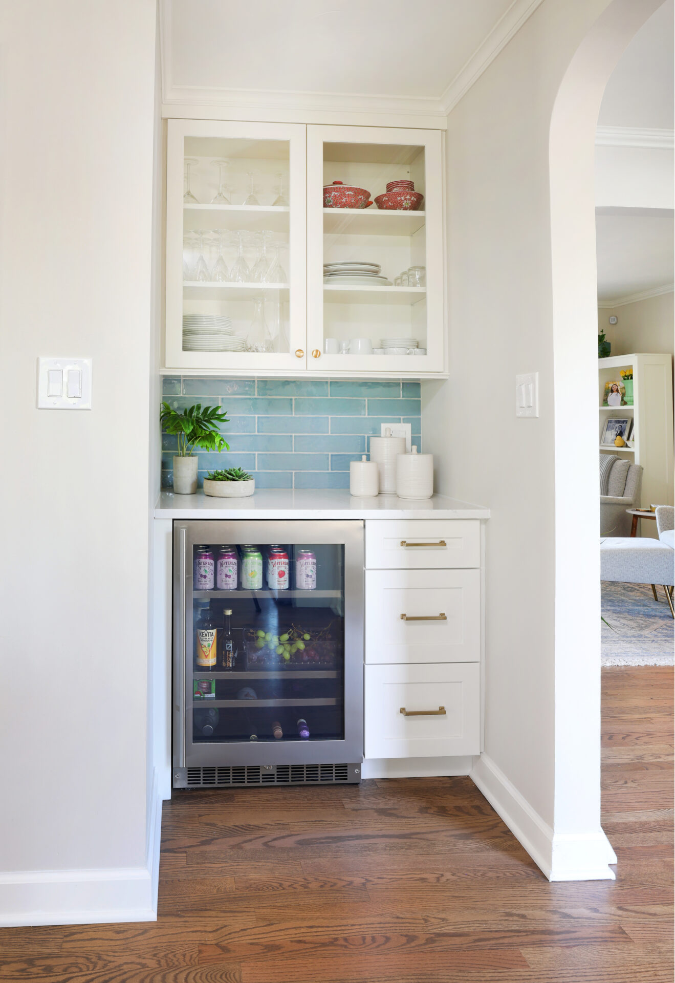 beverage center with open front cabinets and soft blue backsplash