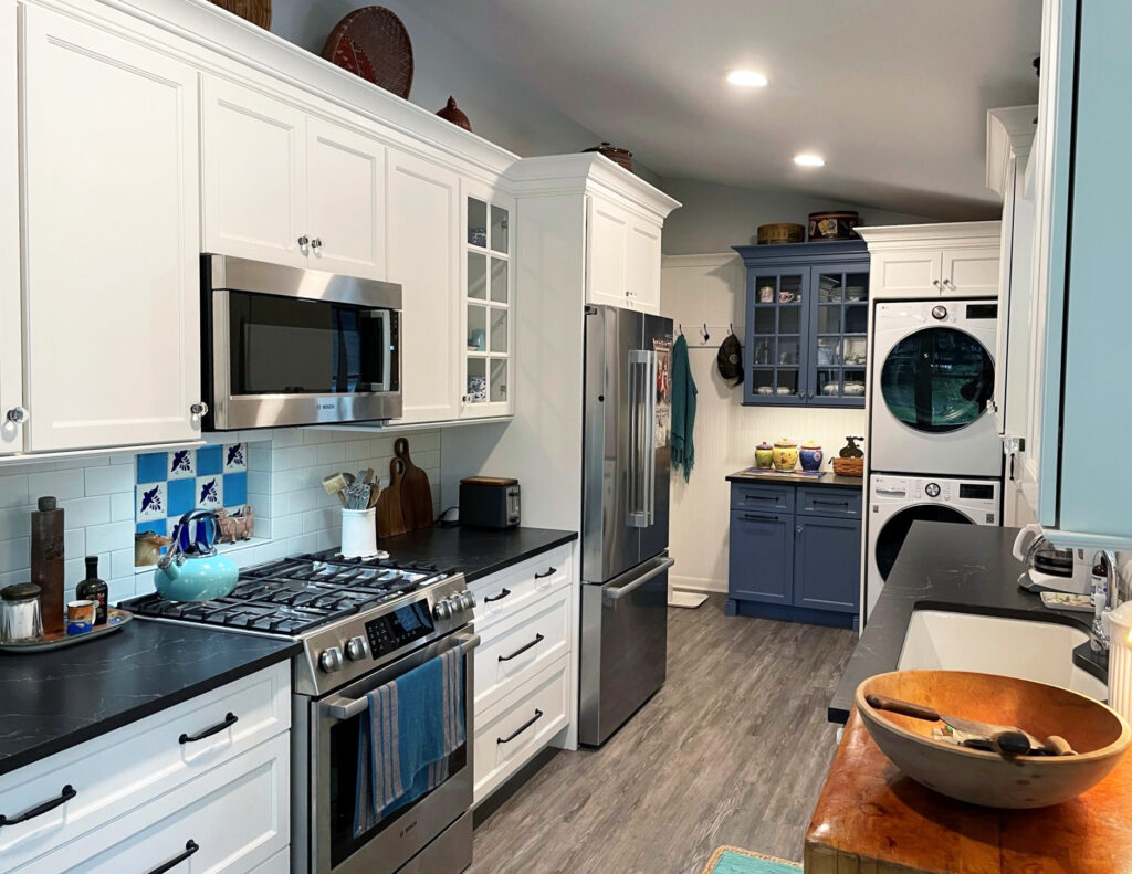 white farmhouse kitchen with dark countertops and beadboard walls