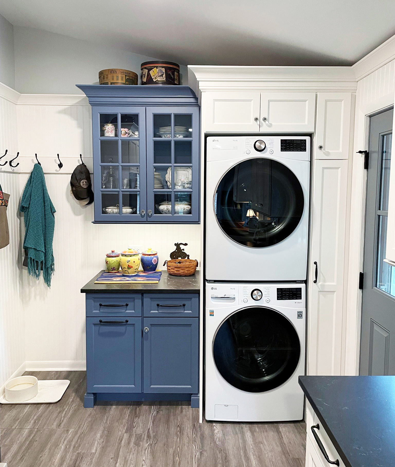 stackable washer dryer unit with blue hutch in farmhouse kitchen