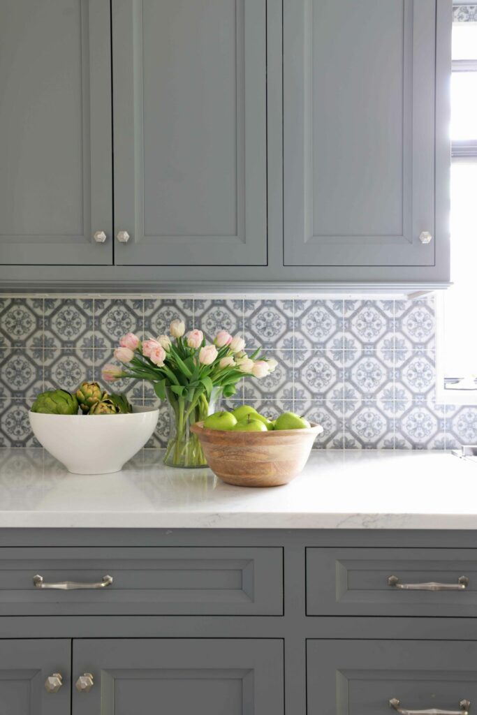 Gray kitchen cabinetry with patterned backsplash tile