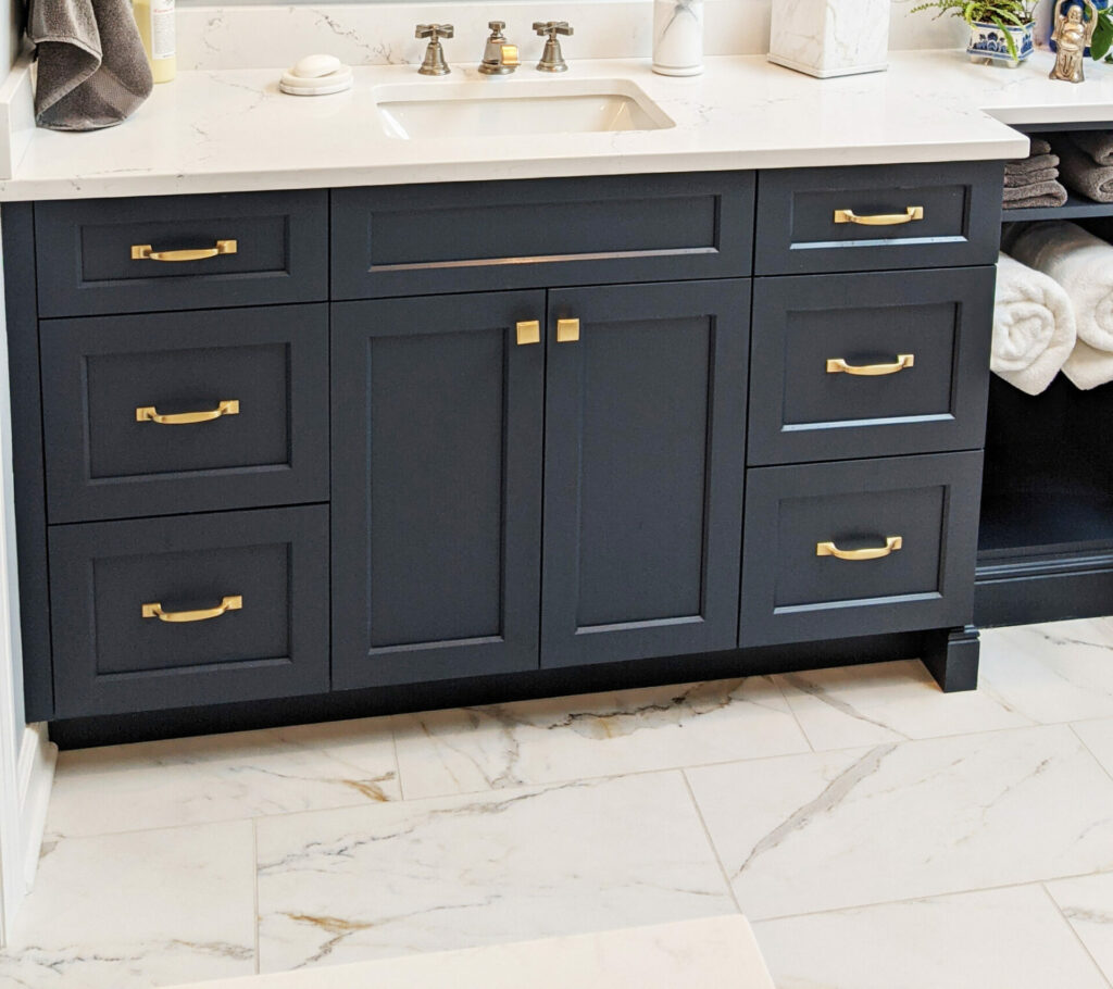 navy vanity with gold hardware in primary vintage bathroom