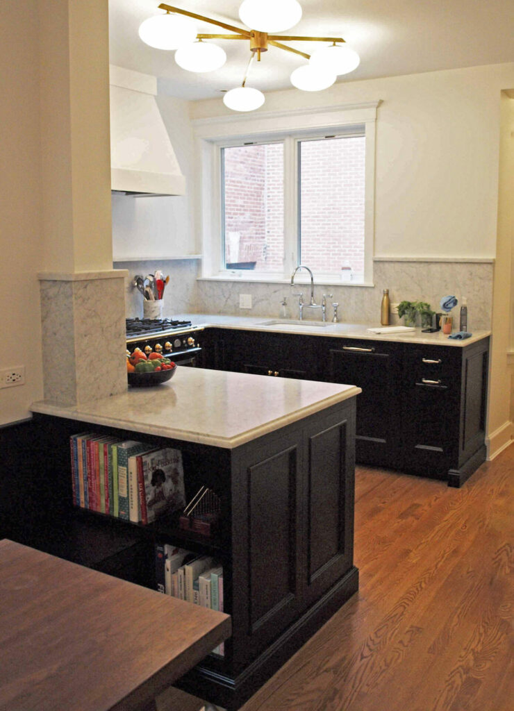 black and white u-shaped kitchen and bookcase on end cap on lower perimeter cabinet