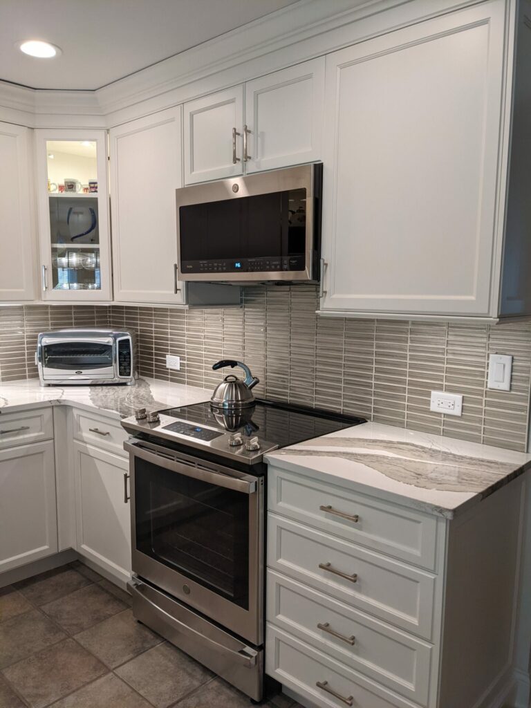 white kitchen with taupe backsplash and microhood