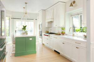 White kitchen with green island and gold accents