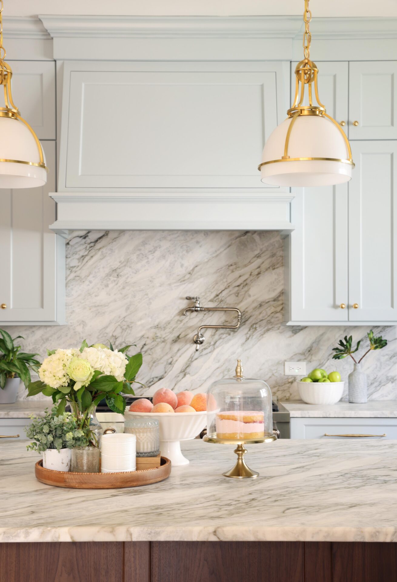 Traditional style soft blue kitchen with cabinetry hood and slab backsplash