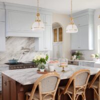 Traditional kitchen with a soft blue paint on the perimeter and a stained kitchen island