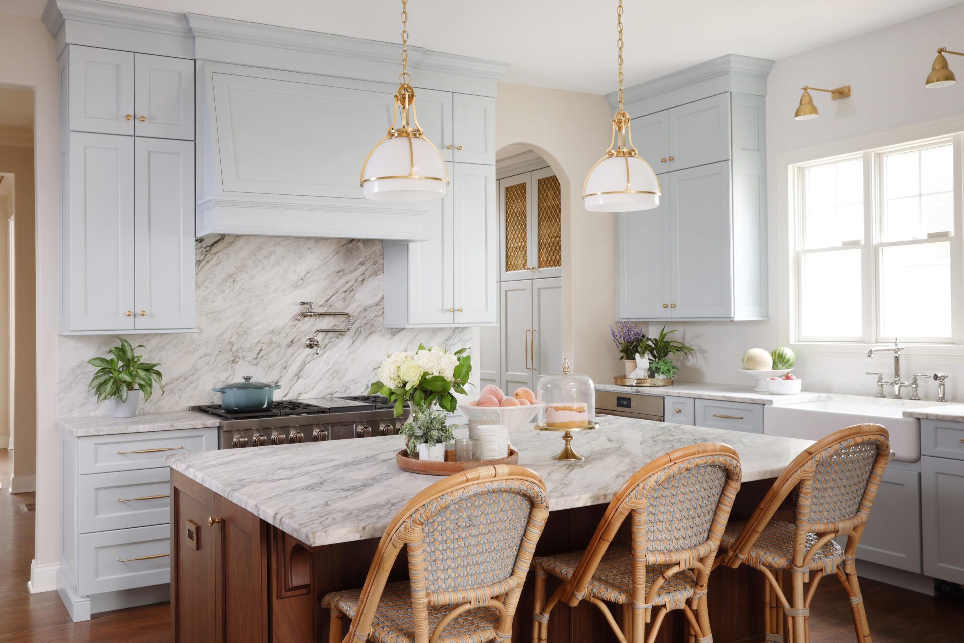 Traditional kitchen with a soft blue paint on the perimeter and a stained kitchen island