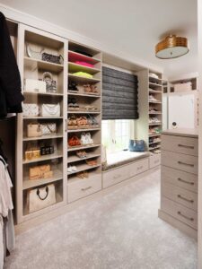 Walk-in closet with custom display space for purses, two towers for shoe storage, upholstered window seat
