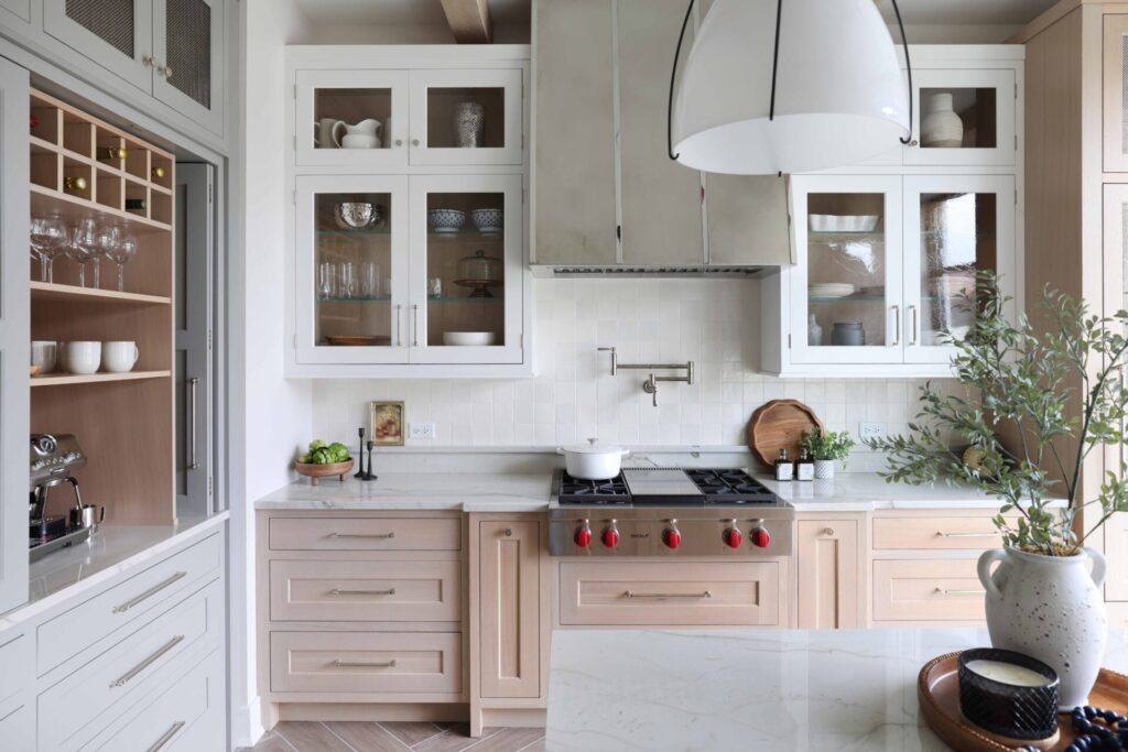 Modern farmhouse kitchen includes custom stainless steel hood with polished nickel strapping.