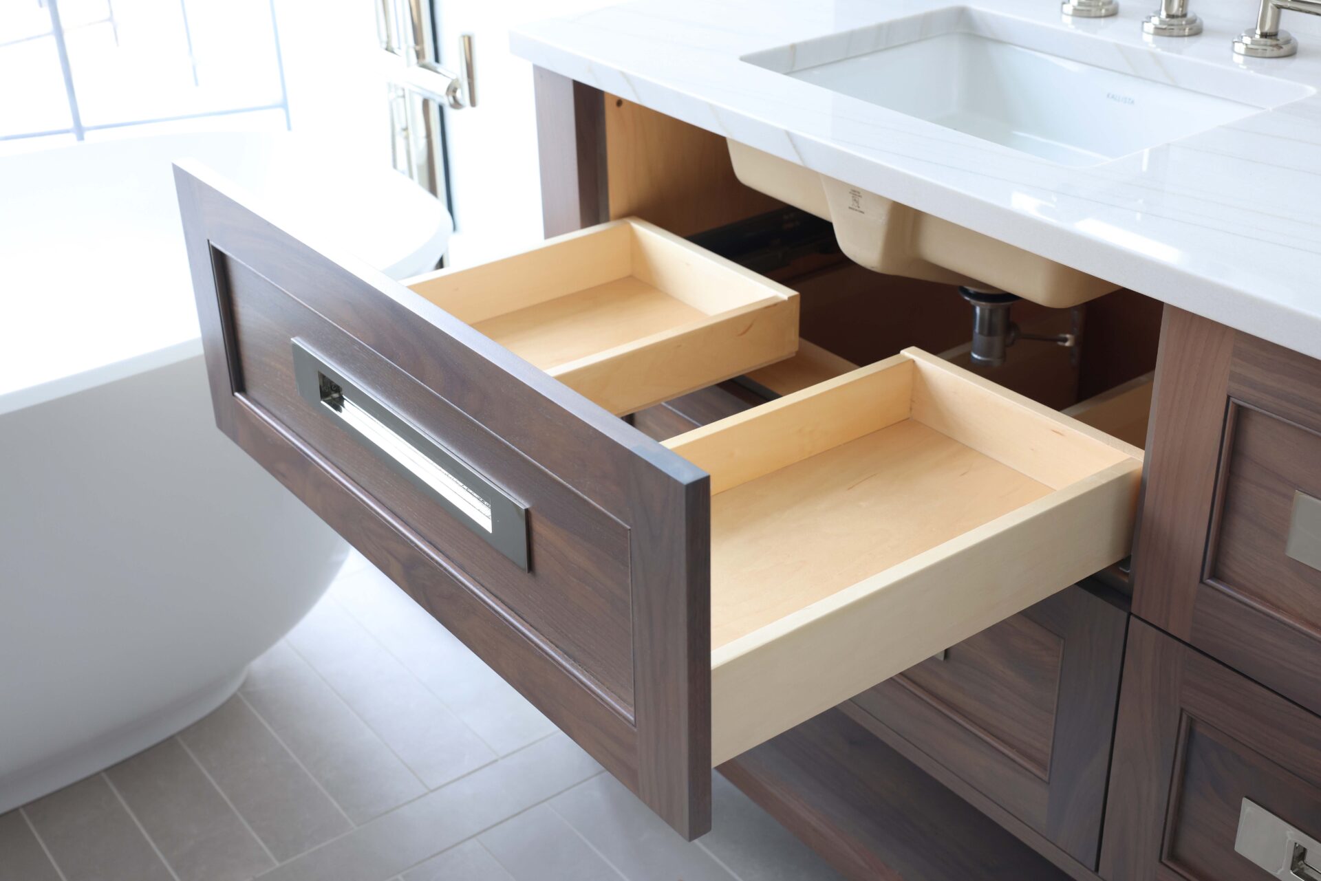 Primary bathroom walnut vanity with top vanity drawer u-shaped interior, polish nickel hardware