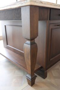 Cherry island with furniture style leg and reeded detail, island shelf