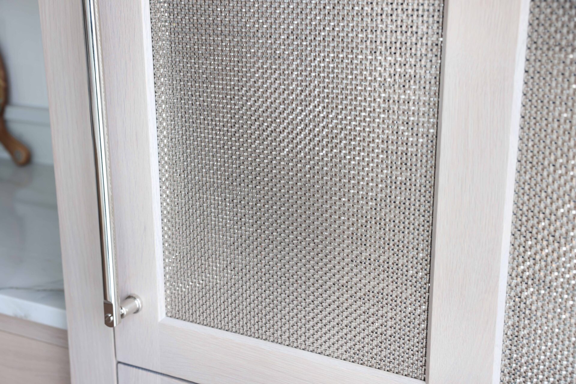 Rift cut white oak paneled refrigerator with polished nickel mesh panels and handle