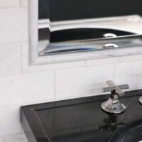 Marble sink, marble backsplash in powder room. Polished nickel faucet, beveled mirror edge