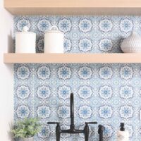 Matte black bridge faucet, blue pattern tile backsplash splash, rift cut white oak floating shelves