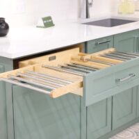 Laundry room with green cabinets, white quartz countertops, polished chrome hardware and drawer with pull out drying rack