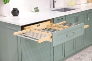 Laundry room with green cabinets, white quartz countertops, polished chrome hardware and drawer with pull out drying rack