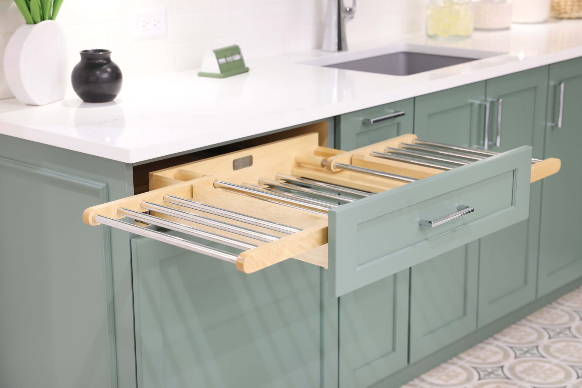 Laundry room with green cabinets, white quartz countertops, polished chrome hardware and drawer with pull out drying rack