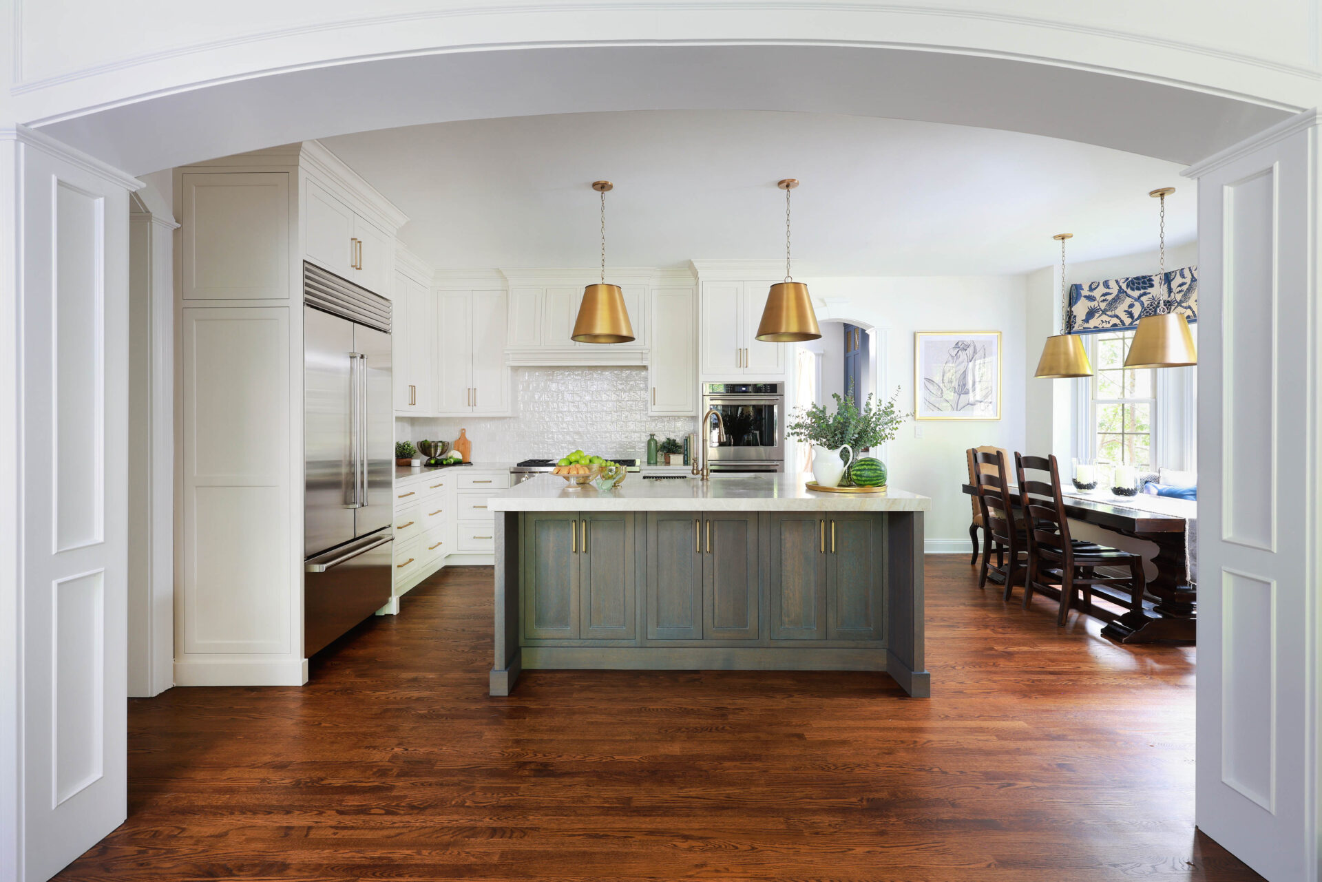 Updated traditional kitchen: In the area where a partial wall used to exist, a graceful arched opening now frames the kitchen, encouraging visitors and natural light to flow through.