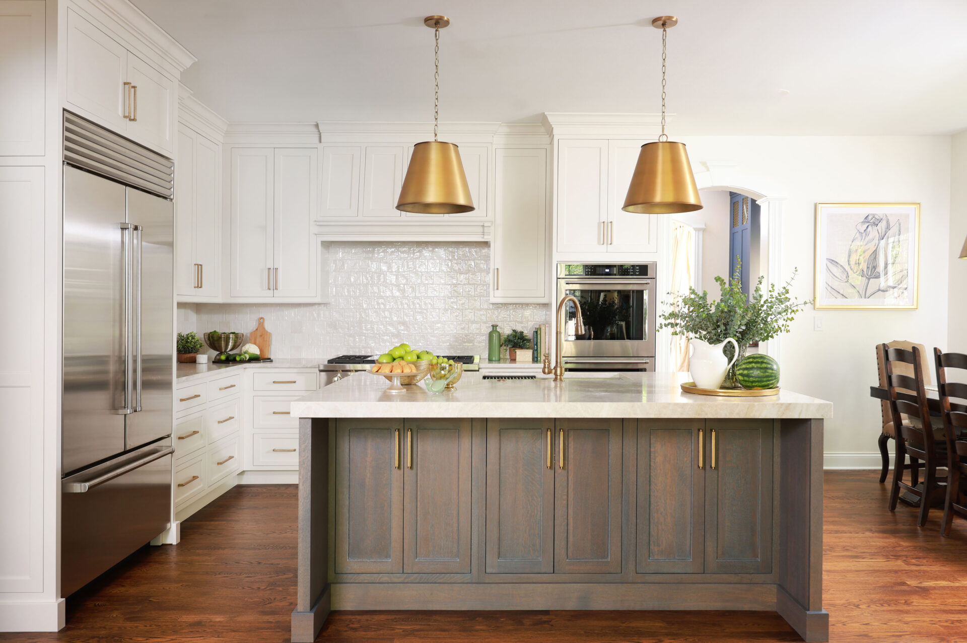 Updated traditional kitchen: A cerused, quarter-sawn oak island with seating for three is capped by a thick slab quartzite countertop with soft gold and grey veining.