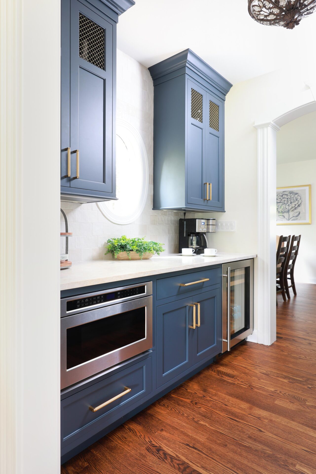 Updated traditional kitchen: In the Butler's pantry, upper cabinets include gold mesh inserts, adding an extra level of detail.