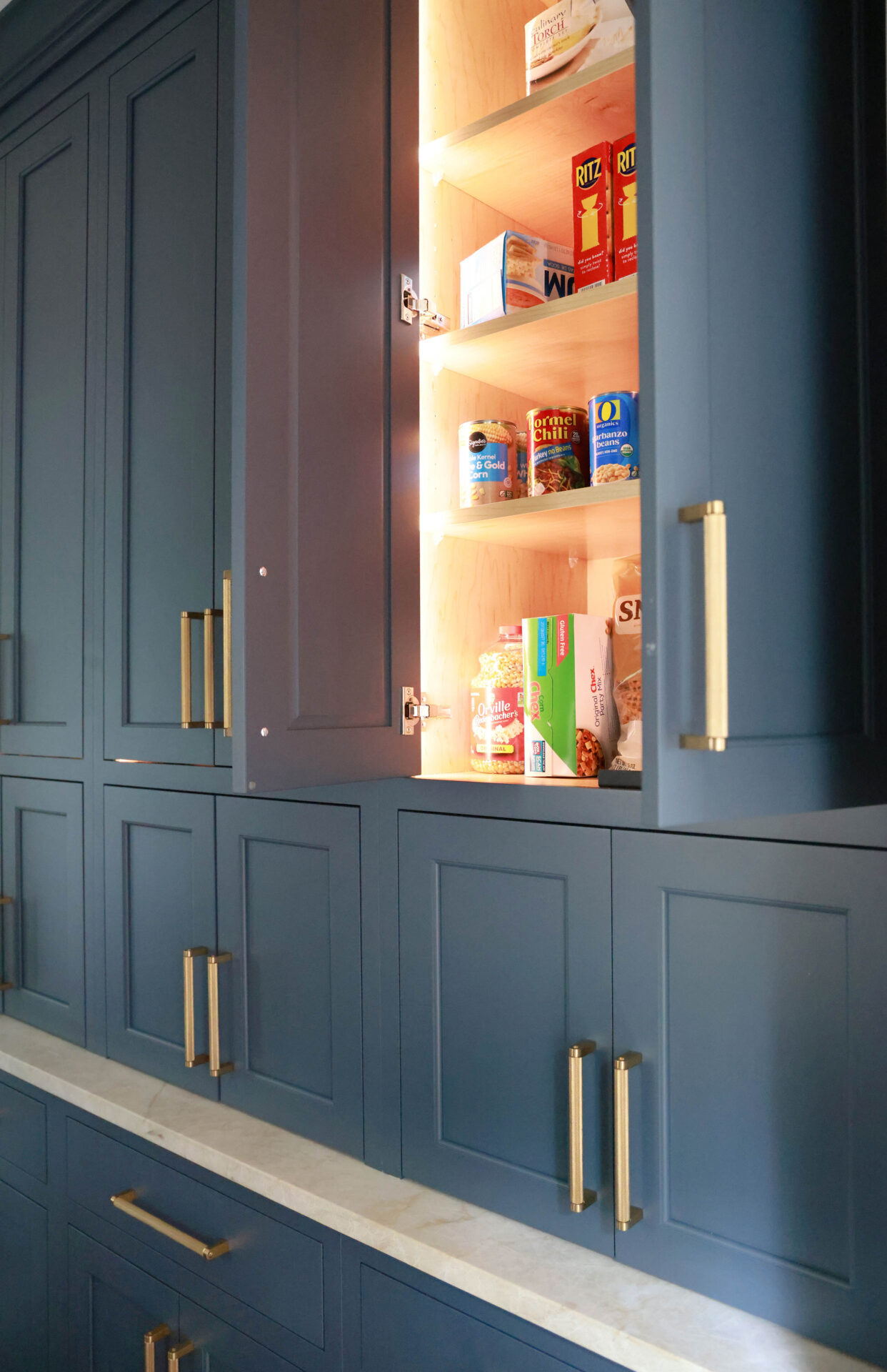 Updated traditional kitchen: In the Butler's pantry, interior cabinet lighting ensures easy visibility on every shelf.