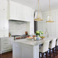 Blue gray quartzite and white hood, kitchen island with seating, fireplace, to the ceiling cabinets
