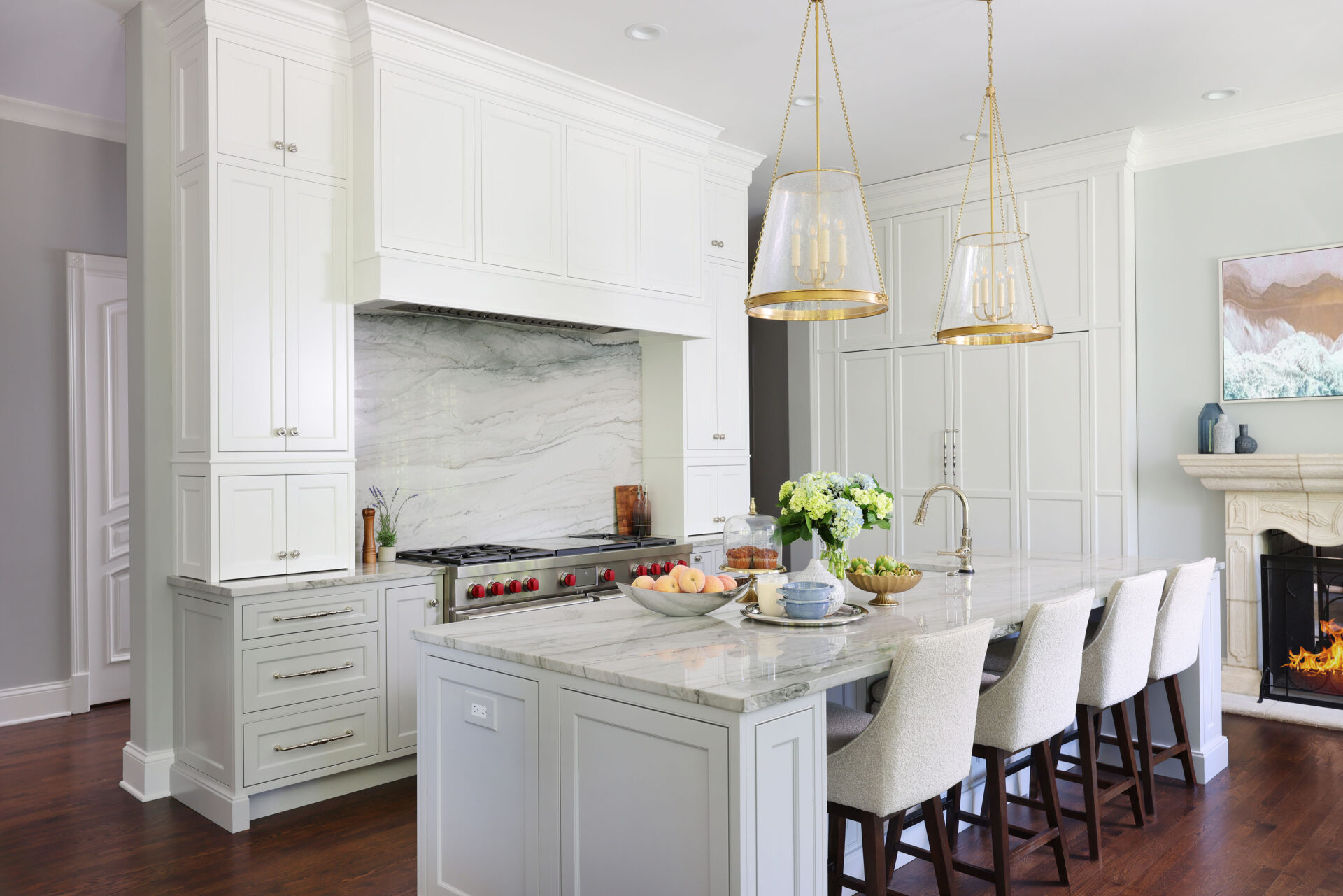Blue gray quartzite and white hood, kitchen island with seating, fireplace, to the ceiling cabinets
