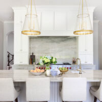 Blue-gray quartzite, gold kitchen lighting, tall cabinets, polished nickel, kitchen island with seating