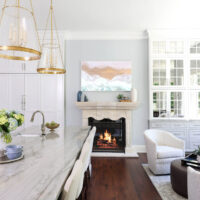 Quartzite countertop kitchen island with seating, fireplace, paneled fridge, sitting area, TV