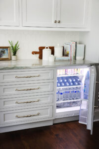 White & gray kitchen with beverage center, door open