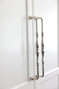 Close-up of polished nickel oversized handles on white paneled fridge