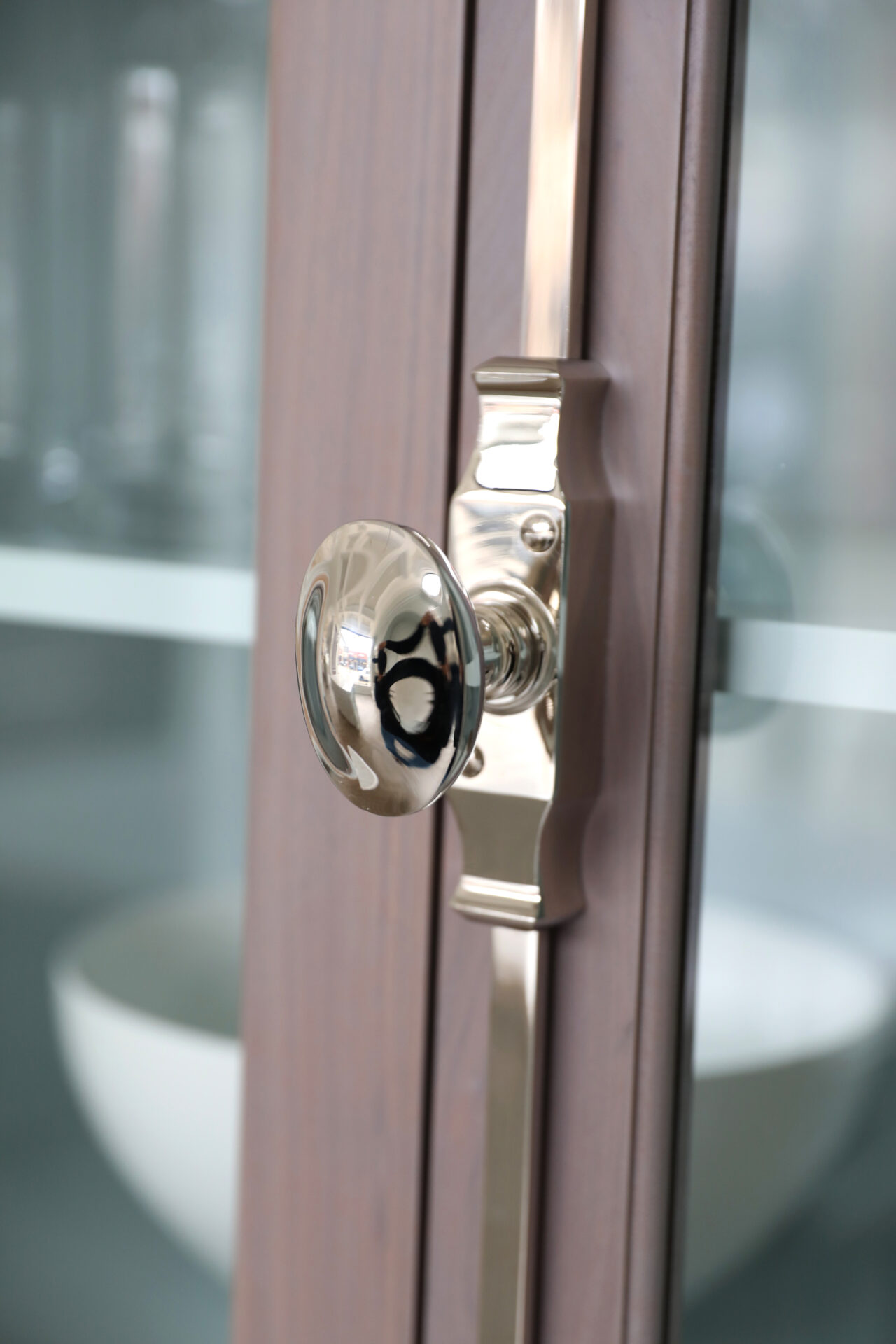 Cabinet latches secure the doors on this traditional glassware cabinet.