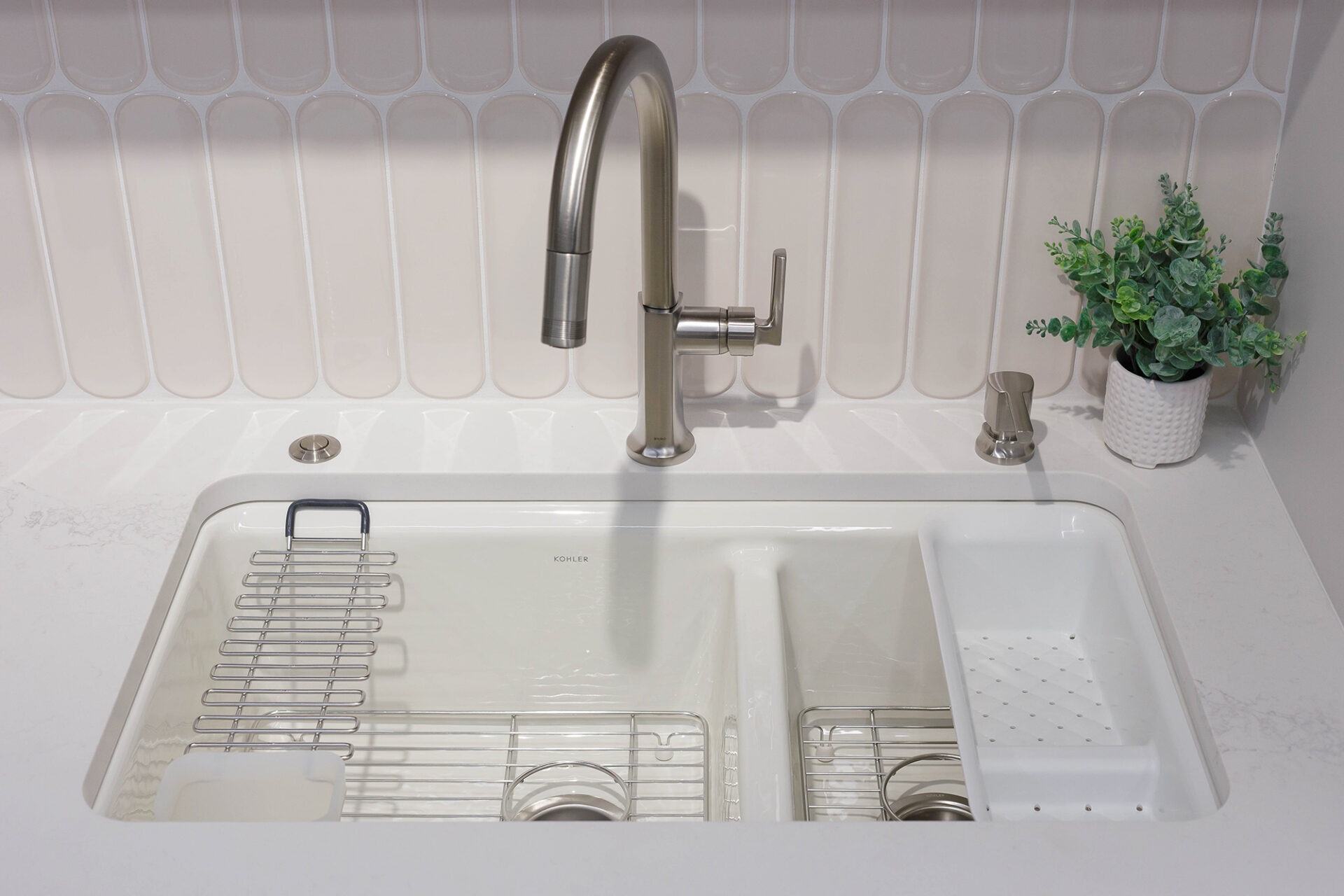 Workstation sink with ledge for accessories, including utility rack and draining tray.